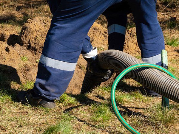 Septic system worker places a tube into the ground