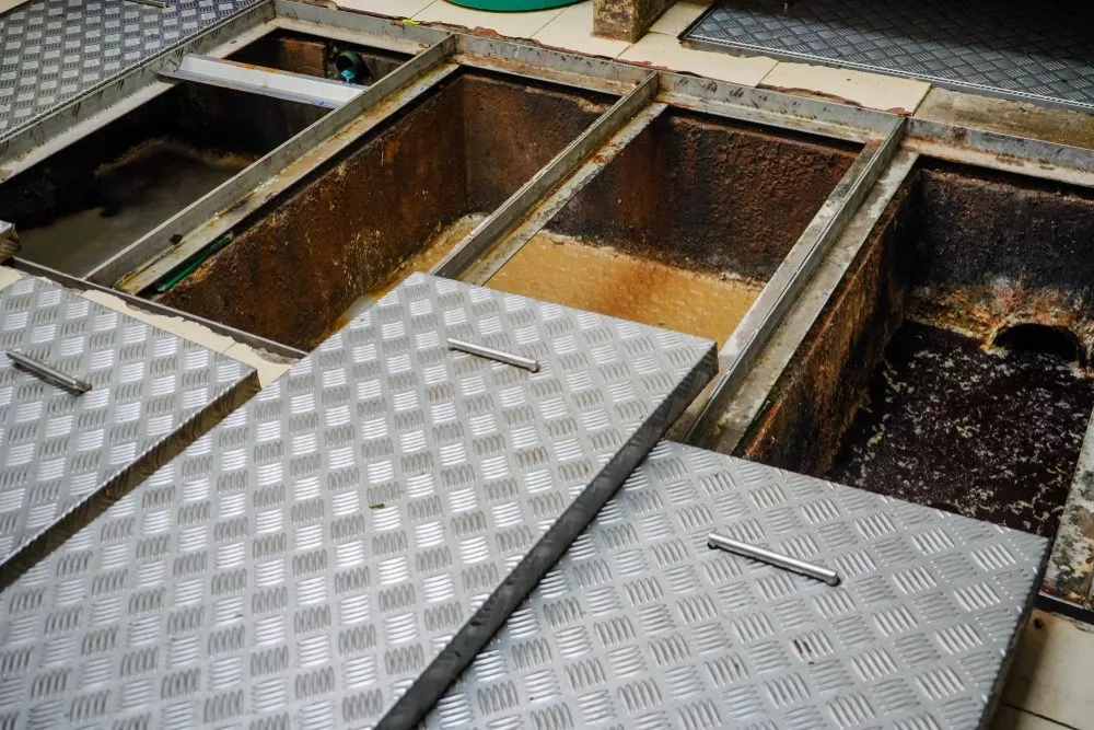Commercial grease traps with lids askew display contents