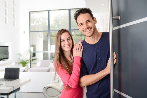 Two smiling customers stand in a doorway
